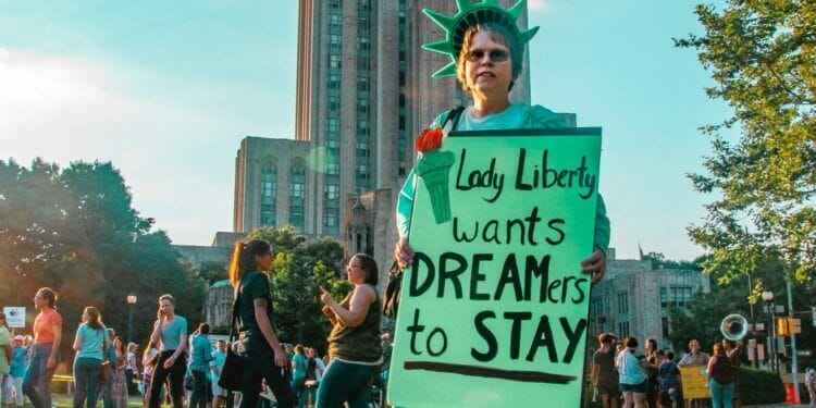 Mujer sosteniendo un cartel que dice "Lady Liberty wants dreamers to stay" - DACA