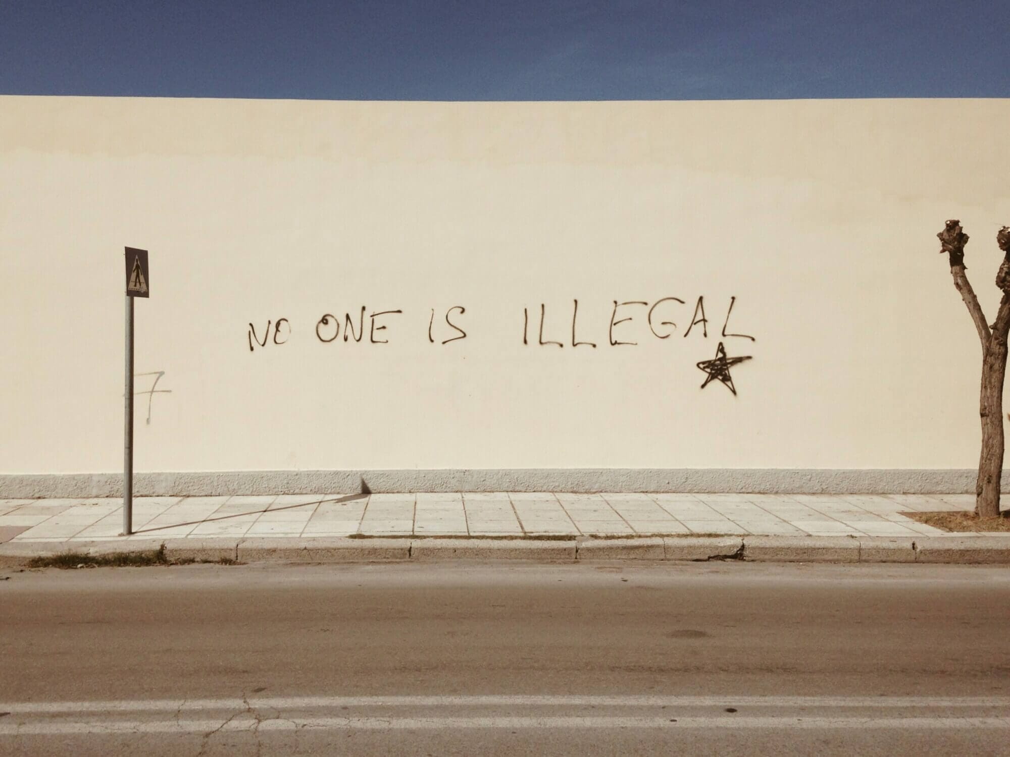 Grafitti que dice "nadie es ilegal" en inglés. En contra del bloqueo de la orden de deportación del bloqueo del juez federal deTexas