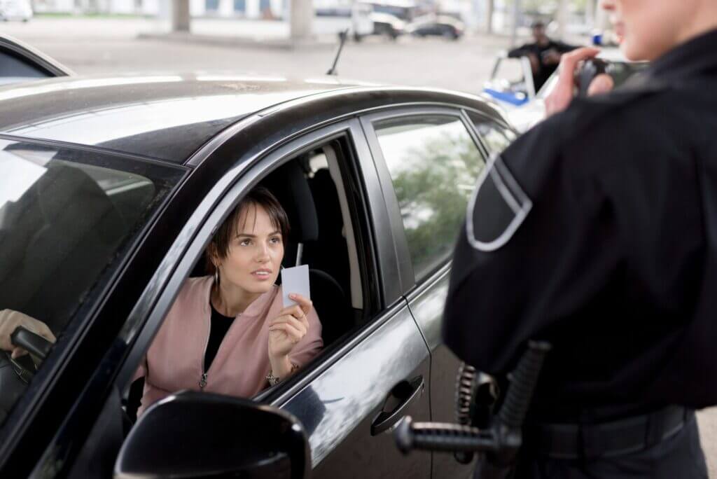Mujer inmigrante mostrando su permiso de conducir en Massachusetts