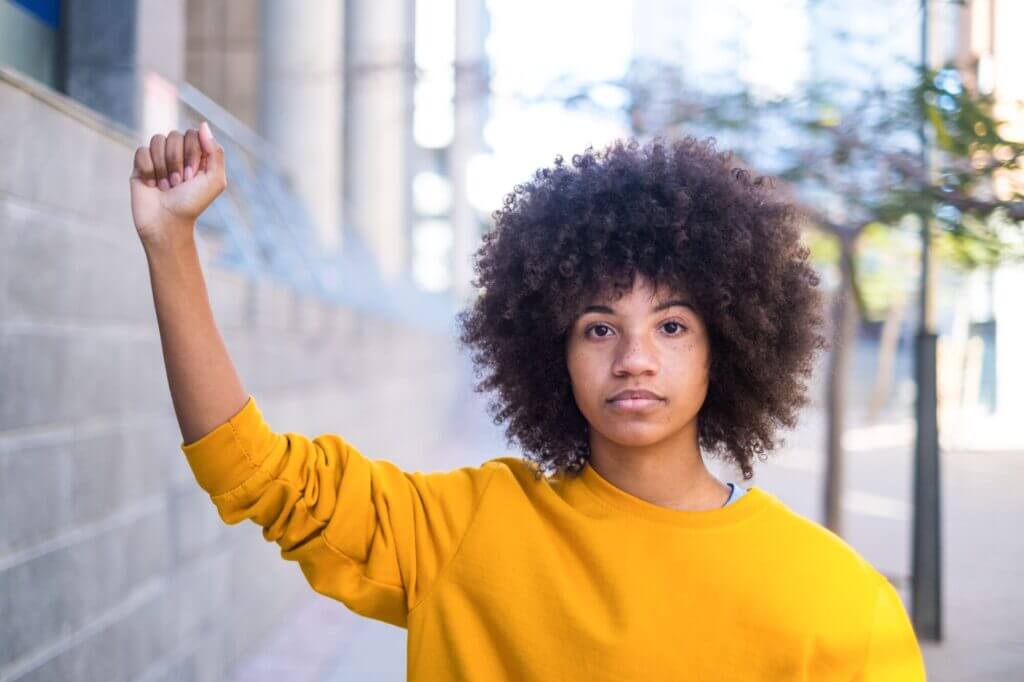 Mujer afrolatina levantando el puño en señal de lucha